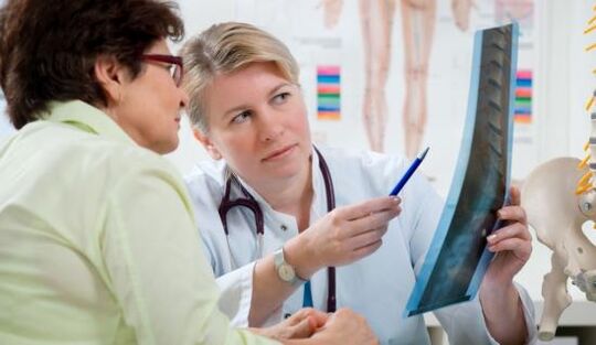 ein Arzt untersucht ein Röntgenbild auf Rückenschmerzen